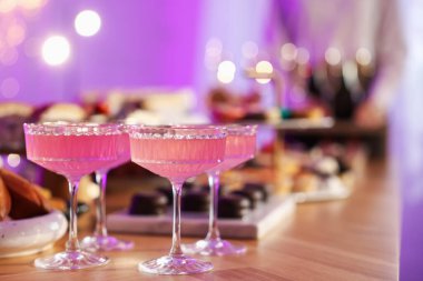 Different delicious desserts, drinks on buffet table and waiter, selective focus