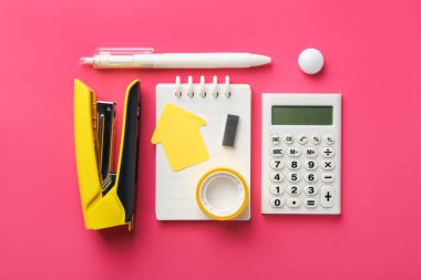 Stapler and other stationery on pink background, flat lay