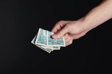 Siyah arka planda dolar banknotları olan adam, yakın plan.