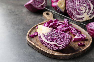 Cut red cabbage on grey table, closeup. Space for text