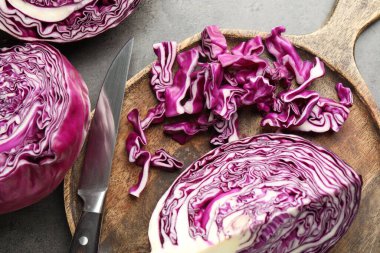 Kırmızıyı kes lahana ve bıçağı gri masaya koy, düz yat