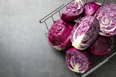 Whole and cut red cabbages on grey table, top view. Space for text
