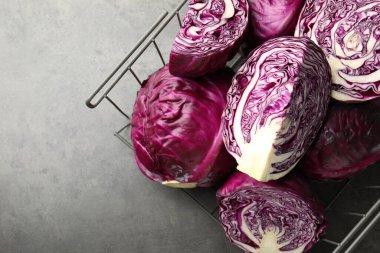 Whole and cut red cabbages on grey table, top view. Space for text