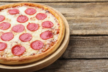 Delicious pepperoni pizza on wooden table, closeup. Space for text
