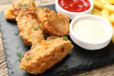 British Traditional Fish and chips with sauces on table, closeup