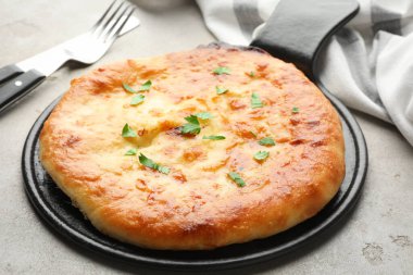 Delicious Megrelian khachapuri served on grey table, closeup