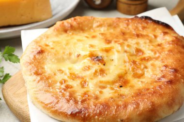 Delicious Megrelian khachapuri on grey table, closeup