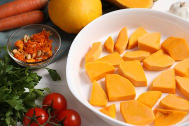 Fresh pumpkins and ingredients on white wooden table, closeup