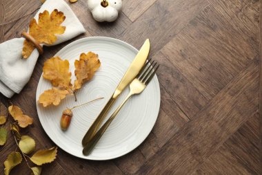 Beautiful table setting with autumn decor on wooden background, flat lay. Space for text