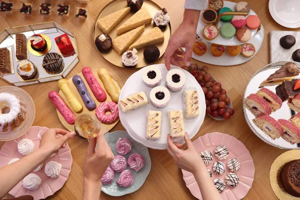 İnsanlar açık büfeden farklı tatlılar yiyorlar.