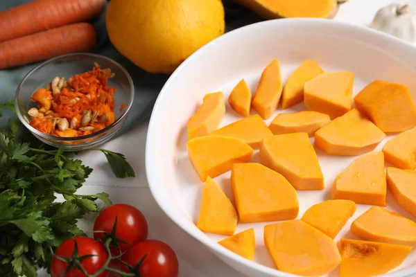 Fresh pumpkins and ingredients on white wooden table, closeup