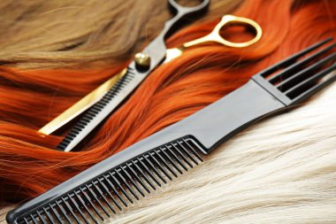 Makas ve tarak farklı renklerde güzel saçlar, yakın çekim.