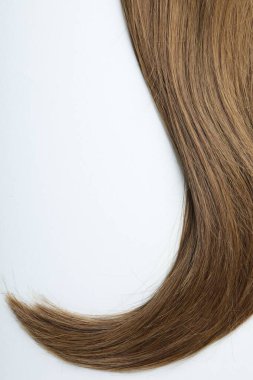 Beautiful hair strand on white background, top view. Space for text