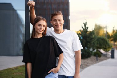 Dışarıda boş tişört giyen genç kadın ve adam. Tasarım için model