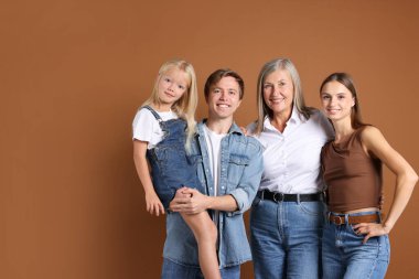 Kahverengi arka planda oğlu ve ailesi olan yaşlı bir kadının portresi.