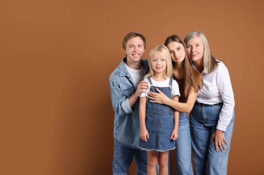 Kahverengi arka planda oğlu ve ailesi olan yaşlı bir kadının portresi. Metin için boşluk