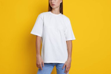 Turuncu arka planda beyaz tişört giyen kadın, yakın plan. Tasarım için model