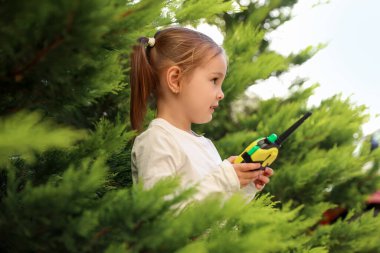 Küçük kız dışarıda telsizle oynuyor.