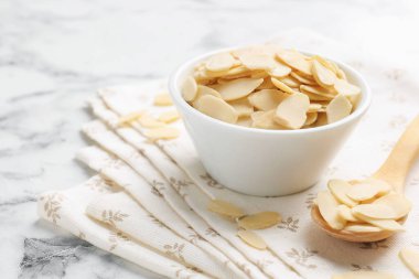 Beyaz mermer masada taze badem taneleri, yakın plan. Metin için boşluk