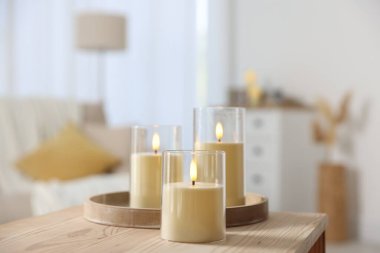 Evdeki ahşap masada dekoratif LED mumlar, yakın plan.