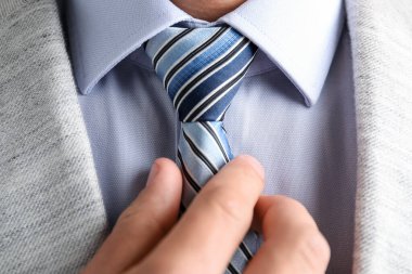 Takım elbiseli adam kravatını düzeltiyor.