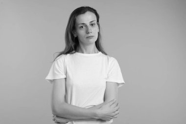 Gri arka planda hayal kırıklığına uğramış bir kadın. Siyah ve beyaz etkisi