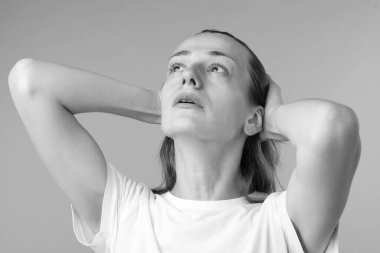 Gri arka planda hayal kırıklığına uğramış bir kadın. Siyah ve beyaz etkisi