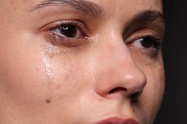 Üzgün kadın siyah arka planda ağlıyor, yakın plan