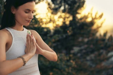 Kadın aurasını iyileştirmek ya da yenilemek için kristalle meditasyon yapıyor.