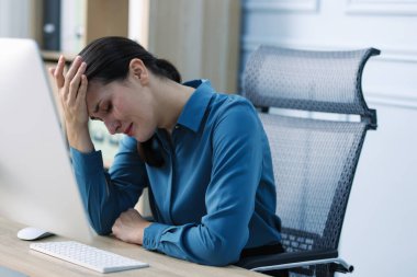 İş kadını ofisteki tahta masada ağlıyor.