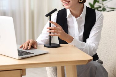 Podcast sunucusu ahşap masa içerisindeki ses içeriğini kaydediyor, yakın plan