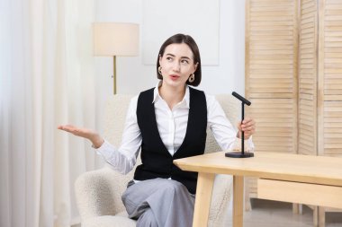 Podcast sunucusu stüdyoda mikrofona konuşuyor