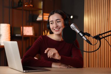 Podcast sunucusu stüdyoda talk show kaydediyor.