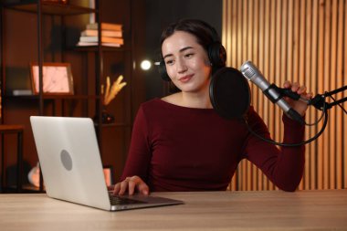 Podcast sunucusu stüdyoda talk show kaydediyor.