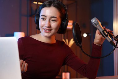 Podcast sunucusu stüdyoda talk show kaydediyor.