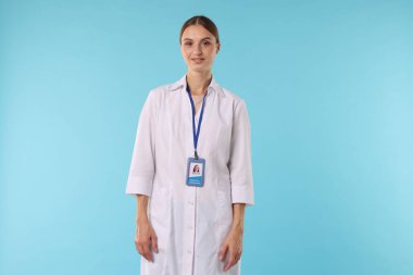 Açık mavi arka planda rozeti olan profesyonel hemşire.