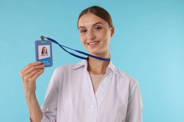 Açık mavi arka planda rozeti olan profesyonel hemşire.