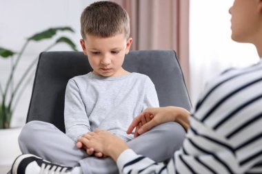 Anne üzgün oğlunu evde destekliyor, yakın plan.