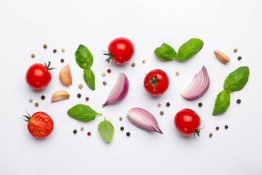 Taze olgun domatesler, fesleğen, soğan ve biberler beyaz arka planda, düz yatıyordu.