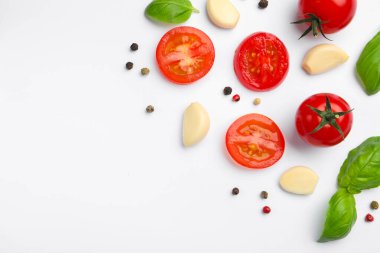 Taze olgun domates, fesleğen, sarımsak ve beyaz arka planda biber, düz. Metin için boşluk