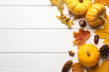 Kuru sonbahar yaprakları, balkabakları, çam kozalakları, kestane ve meşe palamudu beyaz ahşap masa, düz uzanmış. Metin için boşluk