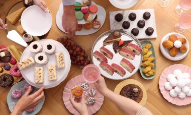 İnsanlar açık büfeden farklı tatlılar ve içecekler alıyor.