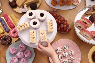 Misafir, açık büfeden lezzetli bir tatlı alıyor.