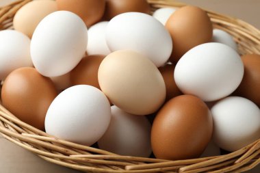 Hasır sepette bir sürü çiğ tavuk yumurtası var.