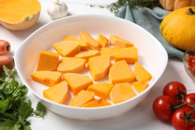 Fresh pumpkins and ingredients on white wooden table, closeup