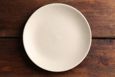 Ahşap masada boş seramik tabak, üst manzara.