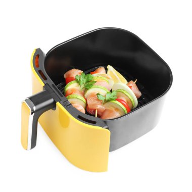 Kızartma sepetinde çiğ tavuk ve sebzeli şişler beyaza izole edilmiş.