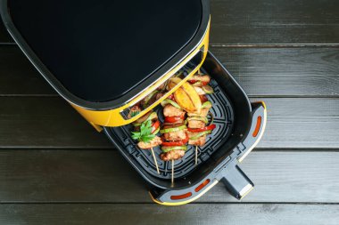 Tavuklu şişler ve tavuklu sebzeler ahşap masada, üst tarafta.