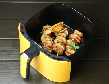 Kızarmış tavuk ve sebzeli şişler ahşap masada, yakın plan.