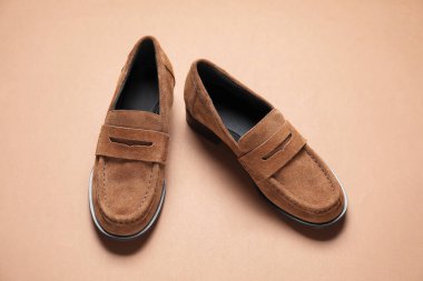 Kahverengi arka planda bir çift şatafatlı deri ayakkabı